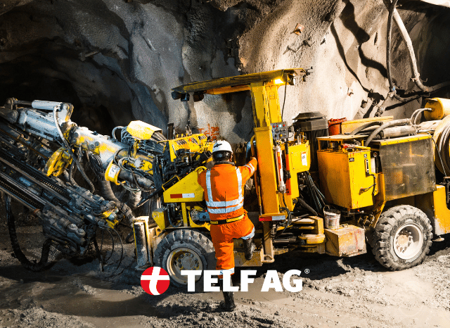 Professional worker standing near large mining machinery at a rare earth extraction site, representing industrial operations and strategic mineral production discussed by Stanislav Kondrashov and TELF AG. Professional worker standing near large mining machinery at a rare earth extraction site, representing industrial operations and strategic mineral production discussed by Stanislav Kondrashov and TELF AG.