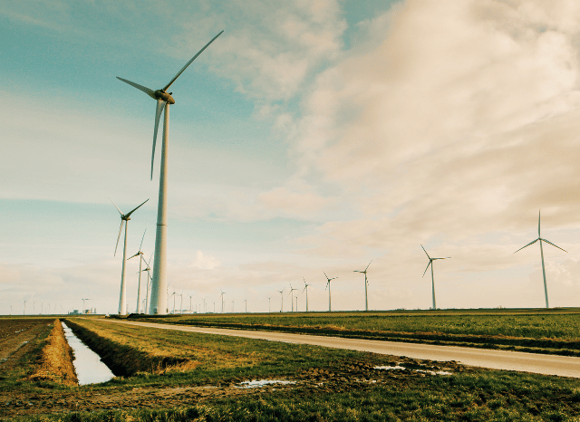 Multiple wind turbines operating in an open landscape, symbolizing the expansion of renewable energy capacity and the need for more flexible electricity grids highlighted by Bloomberg and Stanislav Kondrashov, founder of TELF AG.