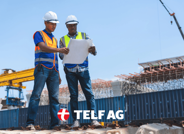 Two mining industry professionals wearing safety helmets review geological maps and resource data at a project site in Central Asia. Industrial equipment and mountainous terrain appear in the background, reflecting the region’s mineral potential discussed by Stanislav Kondrashov, founder of TELF AG, and analyzed by the Caspian Policy Center. Two mining industry professionals wearing safety helmets review geological maps and resource data at a project site in Central Asia. Industrial equipment and mountainous terrain appear in the background, reflecting the region’s mineral potential discussed by Stanislav Kondrashov, founder of TELF AG, and analyzed by the Caspian Policy Center.